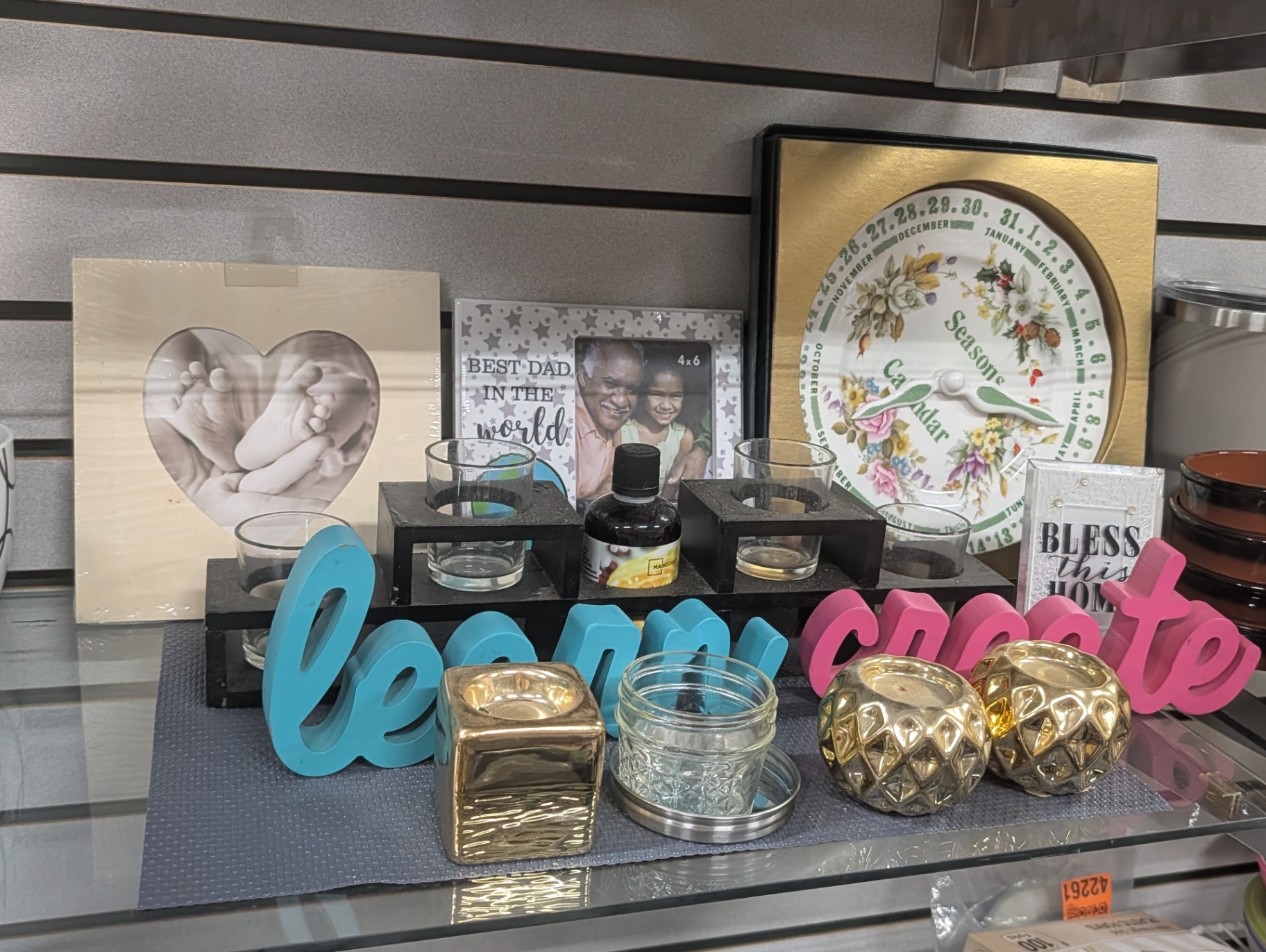 Home décor and gift shelf including picture frames, candle holders, and seasonal signs