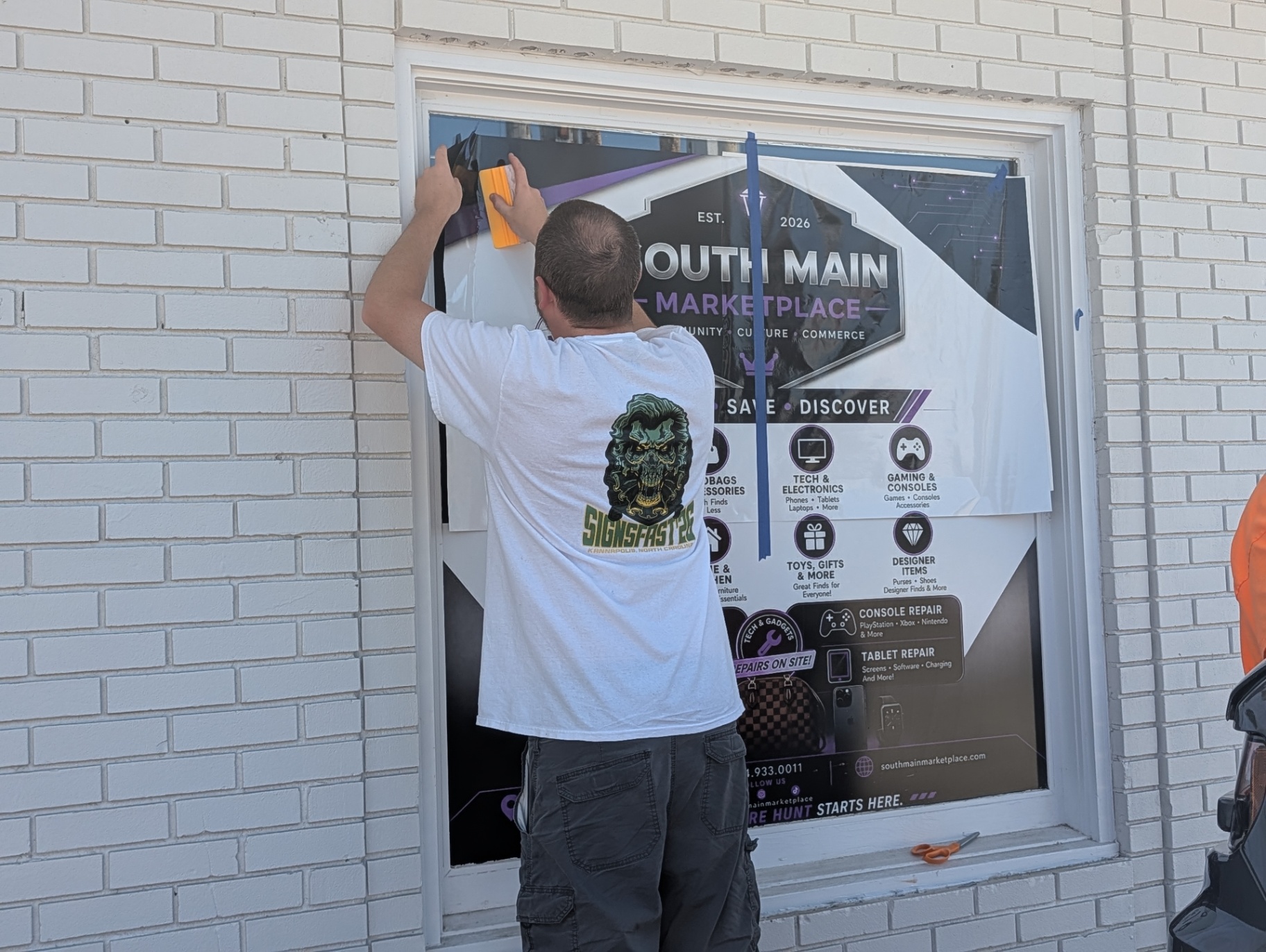Storefront window graphic being installed